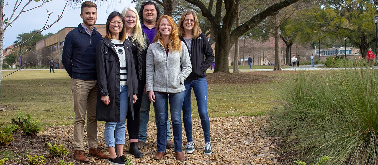 6 students posing together outside