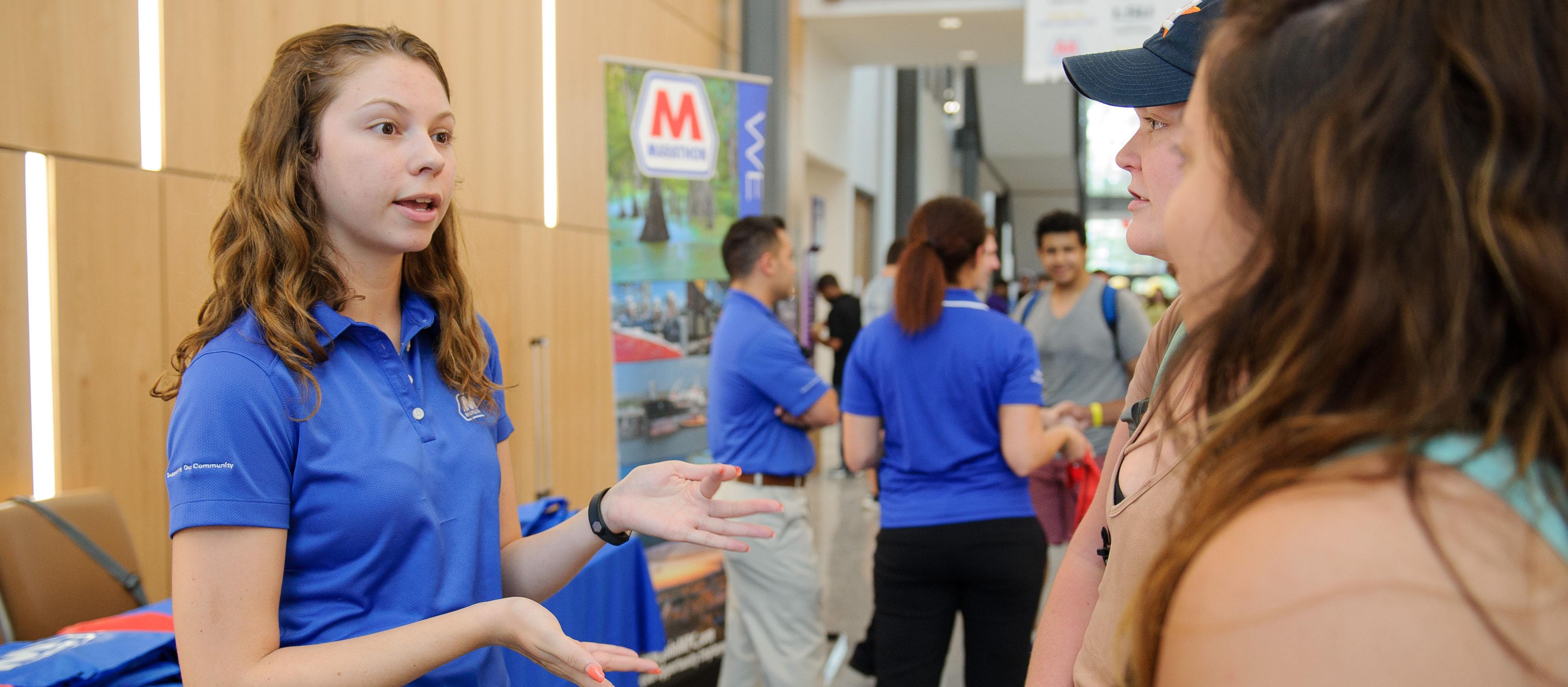 Employer talks with students at an event.